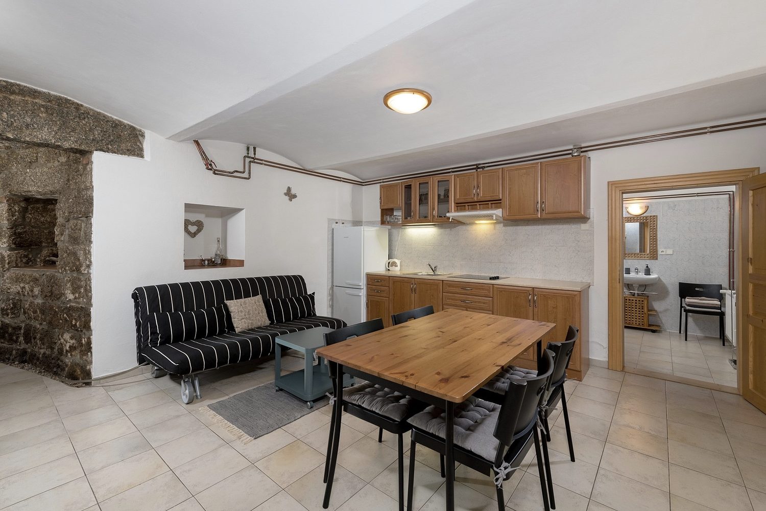Obývací pokoj apartmánu 6 s kuchyňským koutem a krbovými kamny