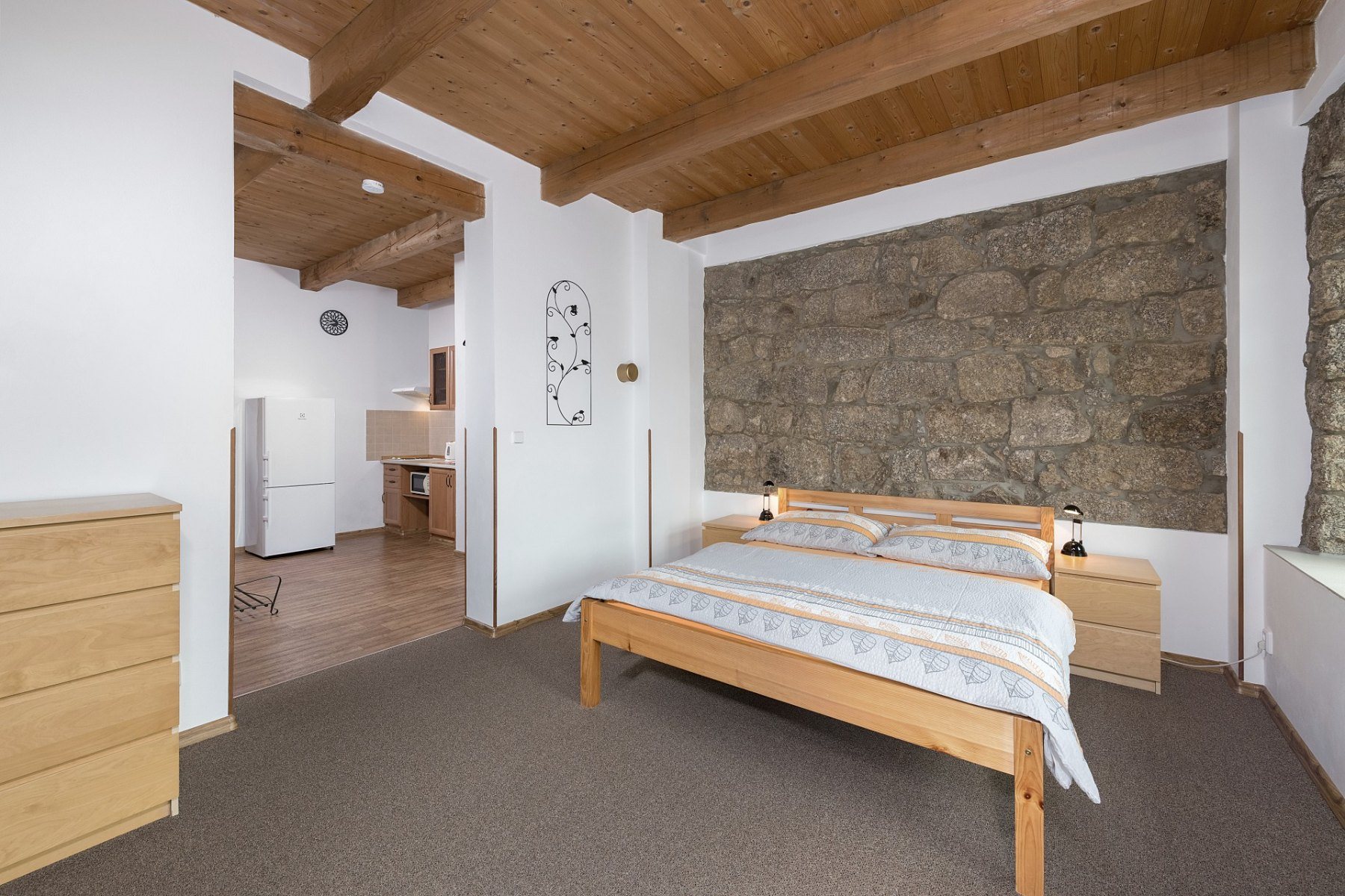 Obývací pokoj apartmánu v penzionu Solaris s odhalenou žulovou zdí a rozkládací pohovkou